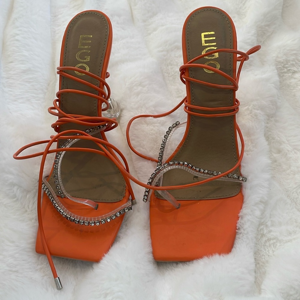 Strappy orange heels adorned with rhinestones and featuring a delicate ankle tie